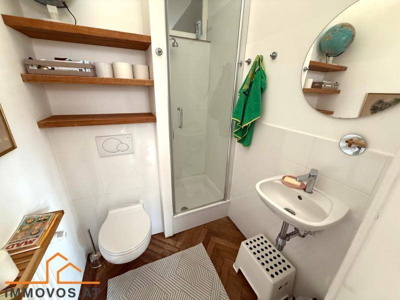 Kleines Badezimmer mit Dusche, Toilette und Waschbecken, praktisch und funktional.
