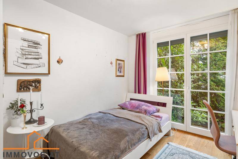 Freundliches Schlafzimmer mit Einzelbett, Holzboden und Zugang zu einem Außenbereich.