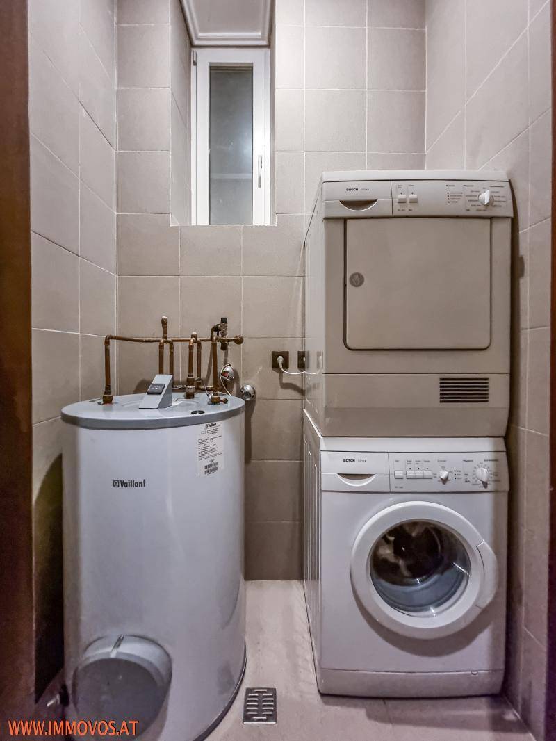 Hauswirtschaftsraum mit Waschmaschine, Trockner und Warmwasserboiler.