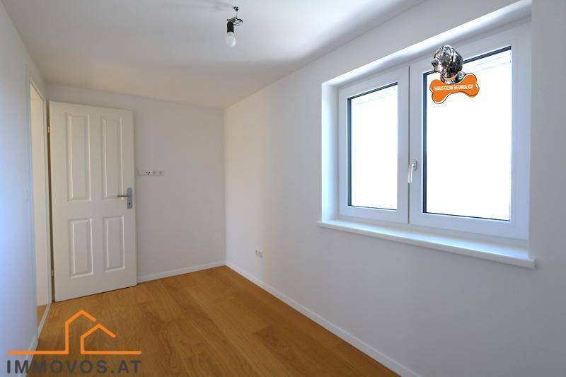 Kleines, helles Zimmer mit Holzboden und einem Fenster, ideal als Kinder- oder Arbeitszimmer.