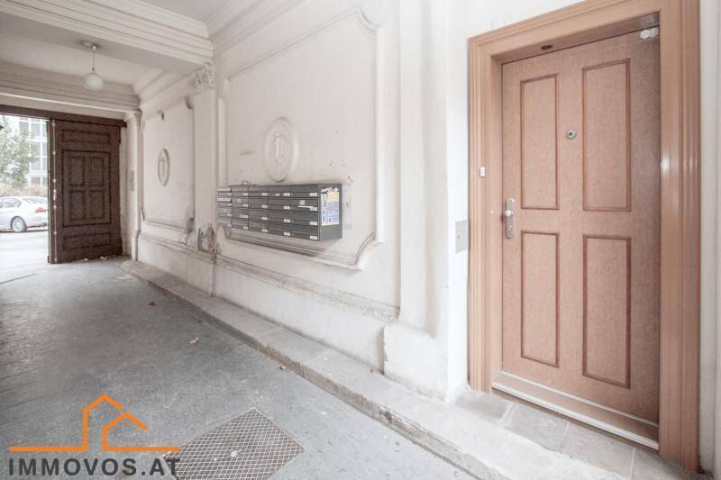 Historischer Eingangsbereich mit Stuckverzierungen, Briefkästen und Holztüren im Altbau.
