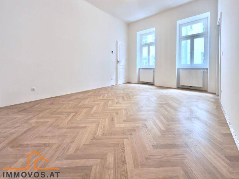 Geräumiges, leeres Zimmer mit Fischgrätparkett und hohen Fenstern, bereit zur individuellen Gestaltung.