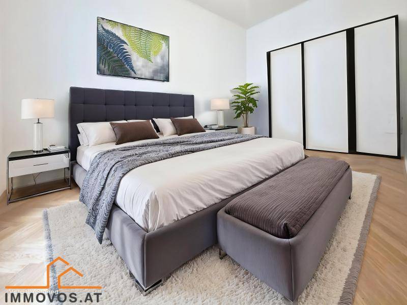 Modern eingerichtetes Schlafzimmer mit großem Bett, Teppich und Einbauschrank.