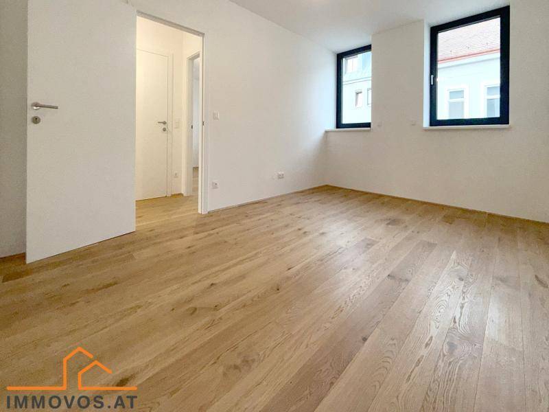 Heller, unmöblierter Raum mit Holzboden und zwei Fenstern, ideal als Büro oder Gästezimmer.