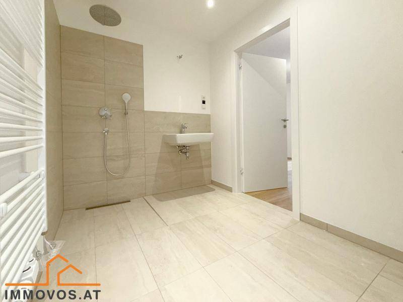 Modernes Badezimmer mit ebenerdiger Dusche, Einzelwaschbecken und Handtuchheizkörper.