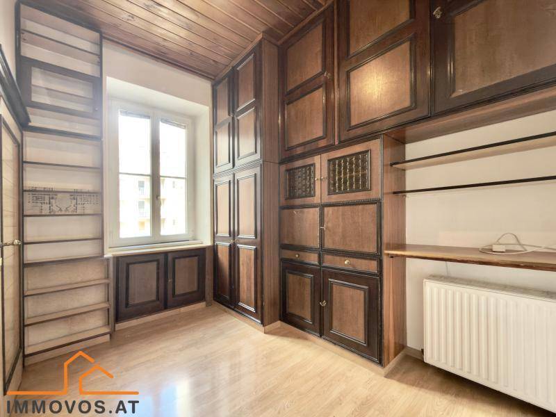 Zimmer mit umfangreichen Einbauschränken aus Holz und Parkettboden, ideal als Schlafzimmer oder Büro.