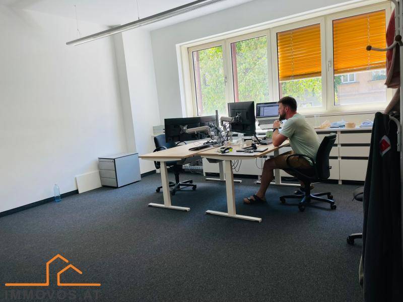 Modern eingerichtetes Büro mit Arbeitsplätzen, Teppichboden und viel Tageslicht.