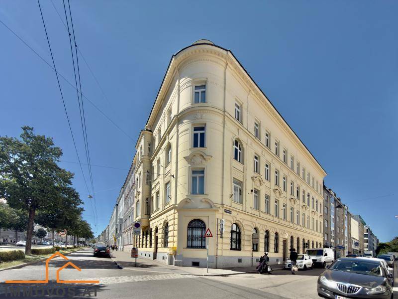 Eckgebäude eines eleganten Altbaus in städtischer Umgebung, mit charakteristischer Architektur und vielen Fenstern.