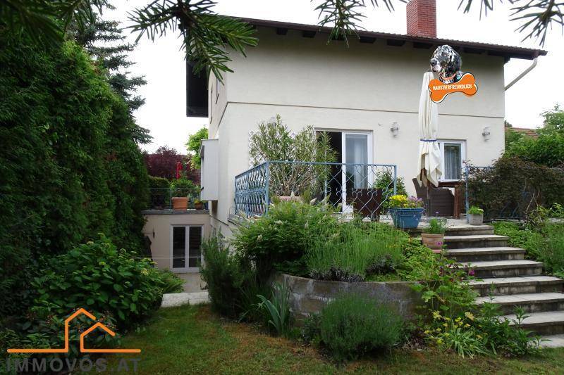 Gepflegter Gartenbereich mit Treppen, bepflanzten Beeten und Zugang zu einer unteren Ebene.