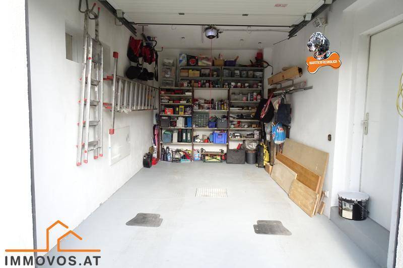 Geräumige Garage mit viel Stauraum und Regalen für Werkzeuge und Haushaltsgegenstände.