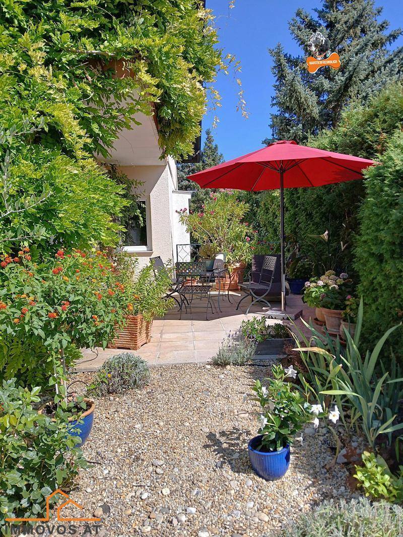 Gepflegter Gartenbereich mit Kiesweg, Blumenbeeten und einer gemütlichen Terrasse.