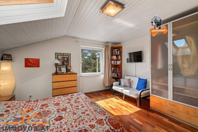 Gemütliches Schlafzimmer mit Holzboden, Dachschräge und Dachfenster für viel Tageslicht.