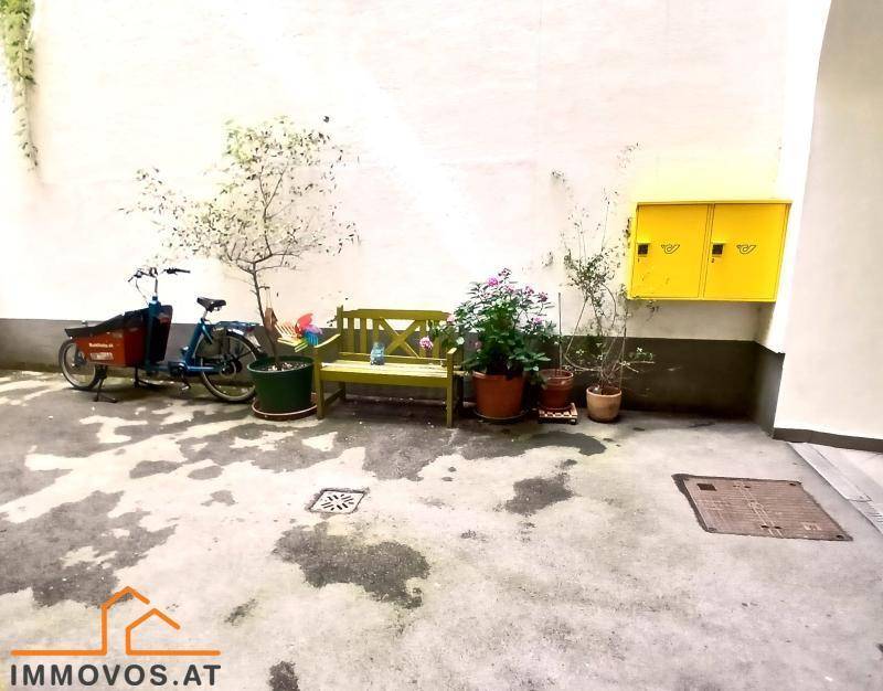 Gemütlicher Innenhof mit Sitzbank, Pflanzen und Fahrrad, bietet einen ruhigen Rückzugsort.