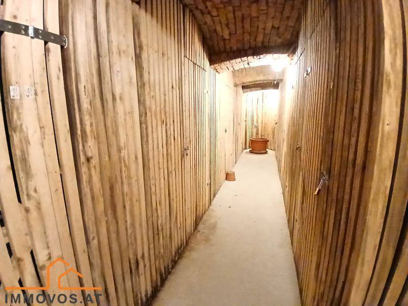 Rustikaler Kellergang mit Holzverkleidung und Ziegeldecke, bietet zusätzlichen Stauraum.