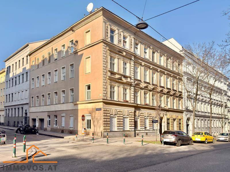 Historisches Eckgebäude mit klassischer Fassade in einer städtischen Umgebung.