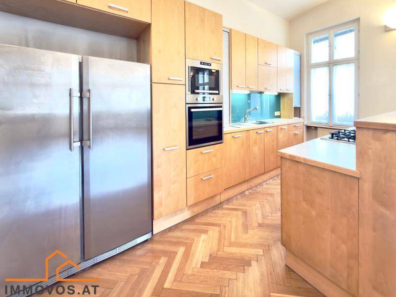 Funktionale Küche mit Holzschränken, integrierten Geräten und einem großen amerikanischen Kühlschrank.