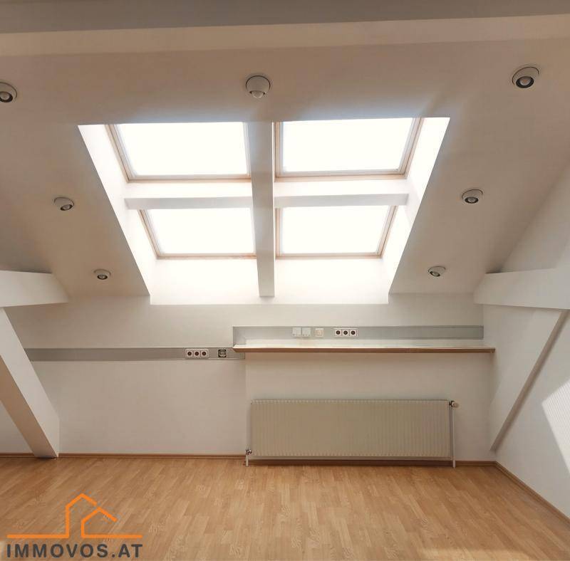 Geräumiger Dachbodenraum mit Holzboden, Dachschrägen und mehreren großen Dachfenstern für viel Licht.