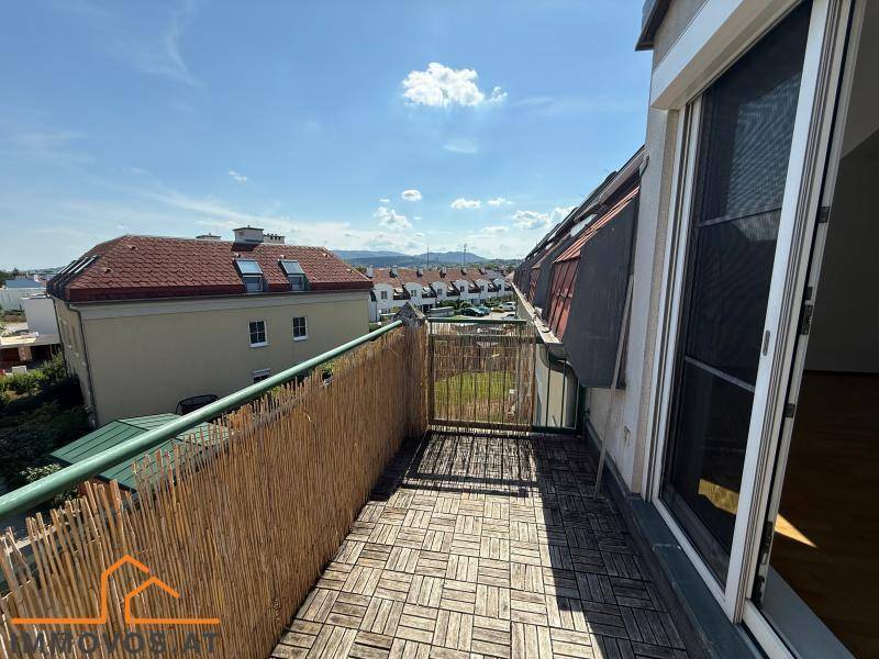 Heller Balkon mit Holzboden und Bambusverkleidung, ideal für entspannte Stunden im Freien.