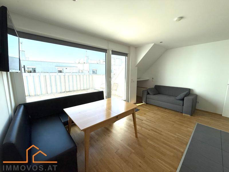 Heller Wohn- und Essbereich mit Sofa, Esstisch und großen Fenstern zur Dachterrasse.