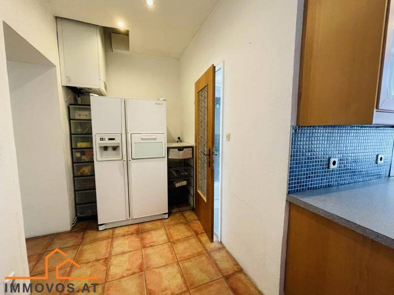 Küchenbereich mit großem Kühlschrank, Gefrierschrank und praktischen Ablagemöglichkeiten.