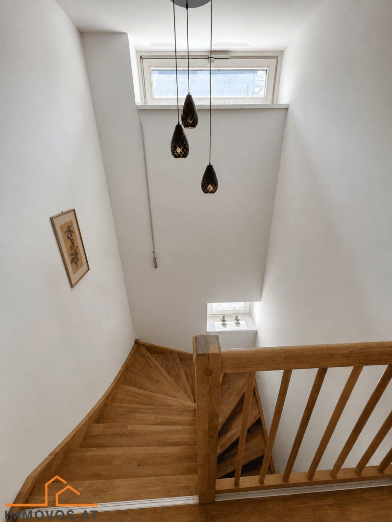 Holztreppe mit Geländer und Oberlicht, die verschiedene Ebenen des Hauses verbindet.
