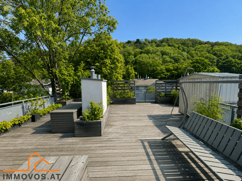 Geräumige Dachterrasse mit Holzboden, Sitzgelegenheiten und Stauraum, umgeben von Bäumen.