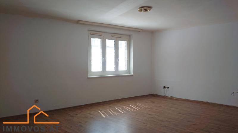 Leerer Raum mit hellen Wänden, einem Fenster und Holzboden, bereit zur individuellen Gestaltung.