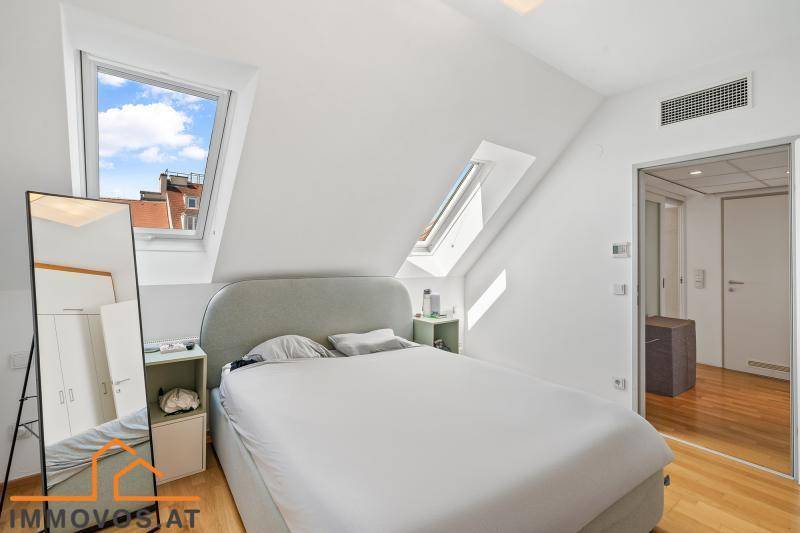 Schlafzimmer mit Dachschrägen, Dachfenstern und Holzboden.