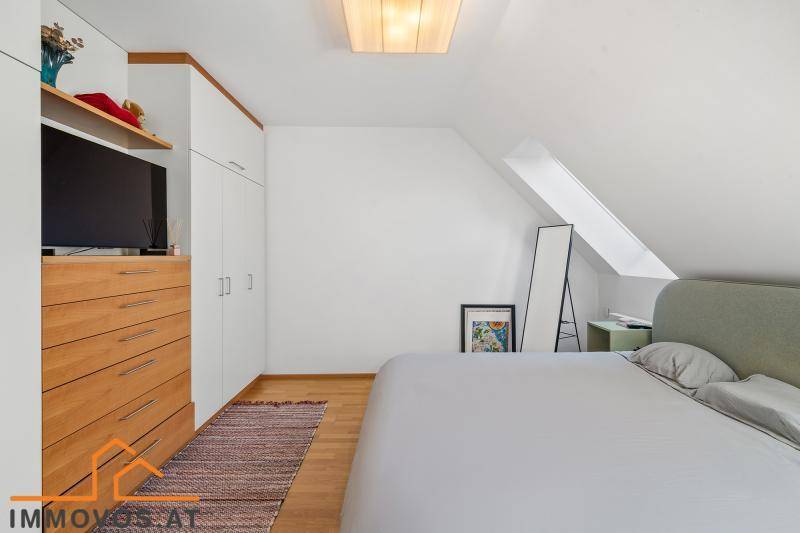 Schlafzimmer mit Einbauschränken, Holzboden und Dachschrägen.