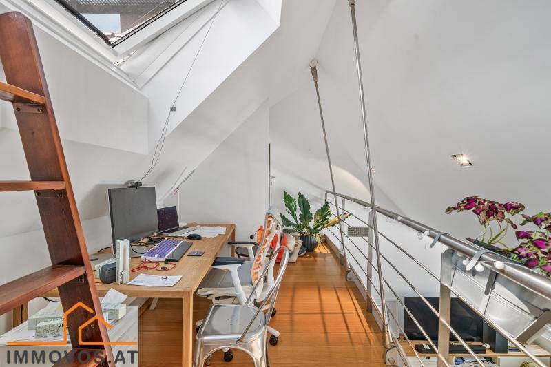Heller Arbeitsbereich auf einer Galerie mit Dachschrägen und Holzboden.