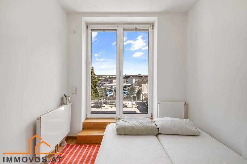 Helles Schlafzimmer mit Balkonzugang und Blick auf die Umgebung.