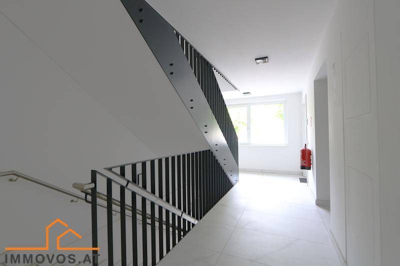 Modernes Treppenhaus mit elegantem Geländer und Fliesenboden, das die Etagen verbindet.