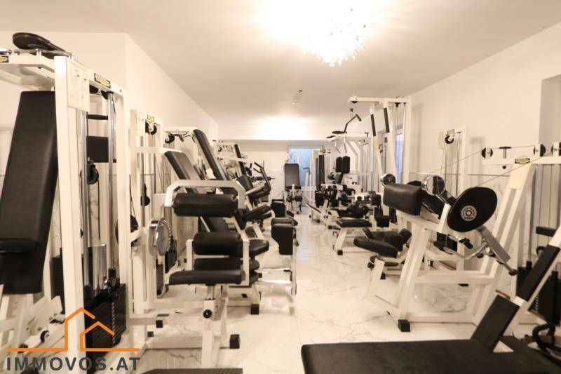 Gut ausgestatteter Fitnessraum mit verschiedenen Trainingsgeräten für die Bewohner des Gebäudes.