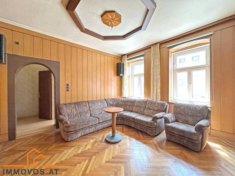 Helles Wohnzimmer mit traditionellem Fischgrätparkett und Holzvertäfelung, ideal für gemütliche Abende.