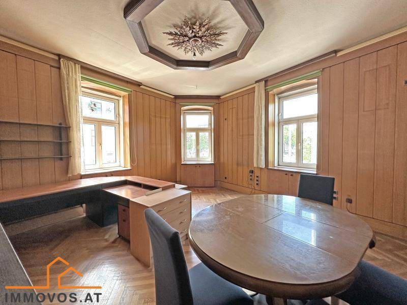 Arbeitszimmer mit Holzvertäfelung, Fischgrätparkett und mehreren Fenstern, ideal für produktives Arbeiten.