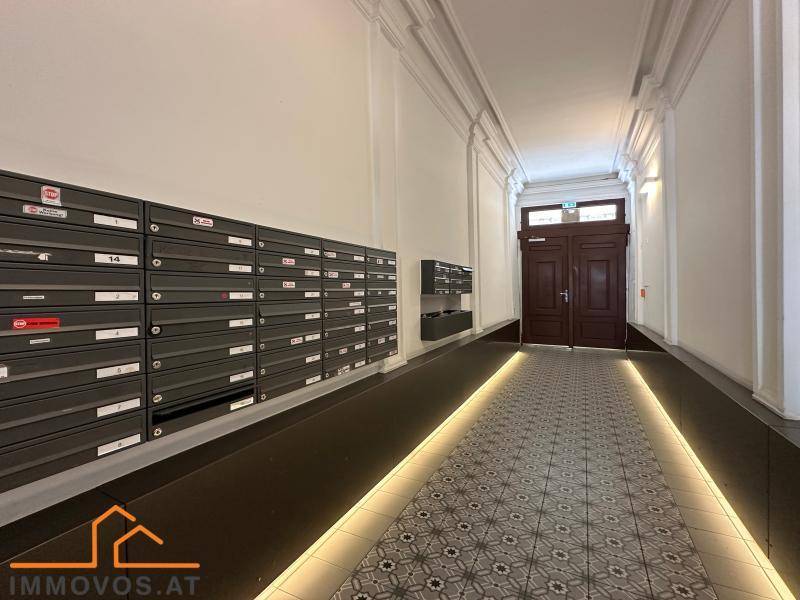 Eingangsbereich mit Briefkästen und einer Rampe, die zum Hauptportal des Gebäudes führt.