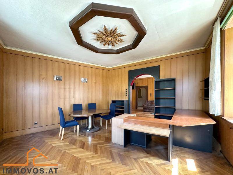 Großzügiges Arbeitszimmer mit Holzboden und Deckenverzierung, bietet Raum für Kreativität und Besprechungen.