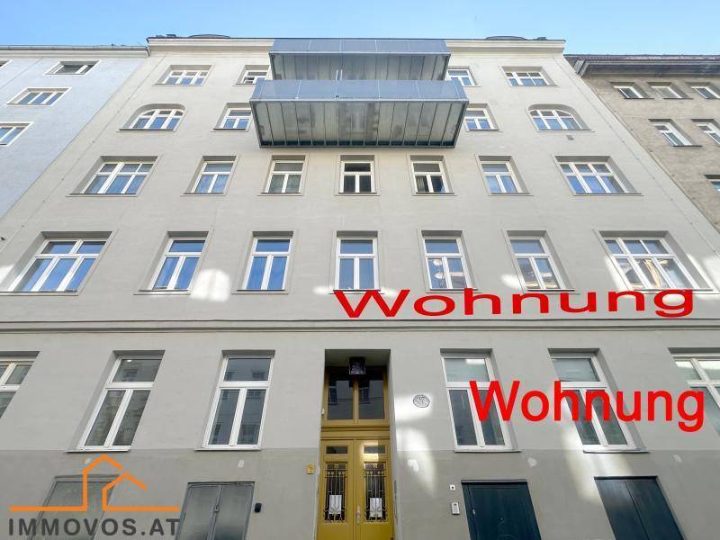 Fassade eines Mehrfamilienhauses mit zahlreichen Fenstern und Balkonen.