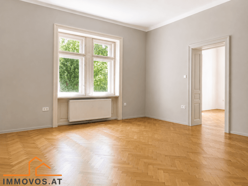 Lichtdurchflutetes Zimmer mit Fischgrätparkett und Blick ins Grüne, ideal für Wohn- oder Schlafbereich.