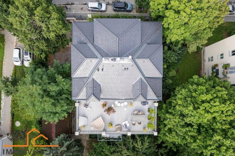 Vogelperspektive des Gebäudes mit detaillierter Dachstruktur und der möblierten Dachterrasse.