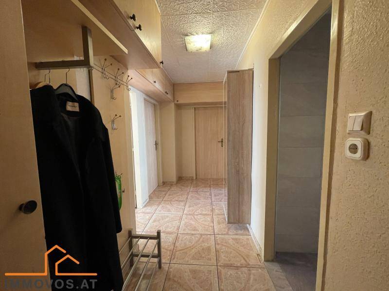 Eingangsbereich mit Fliesenboden, Garderobe und Zugang zu verschiedenen Räumen.