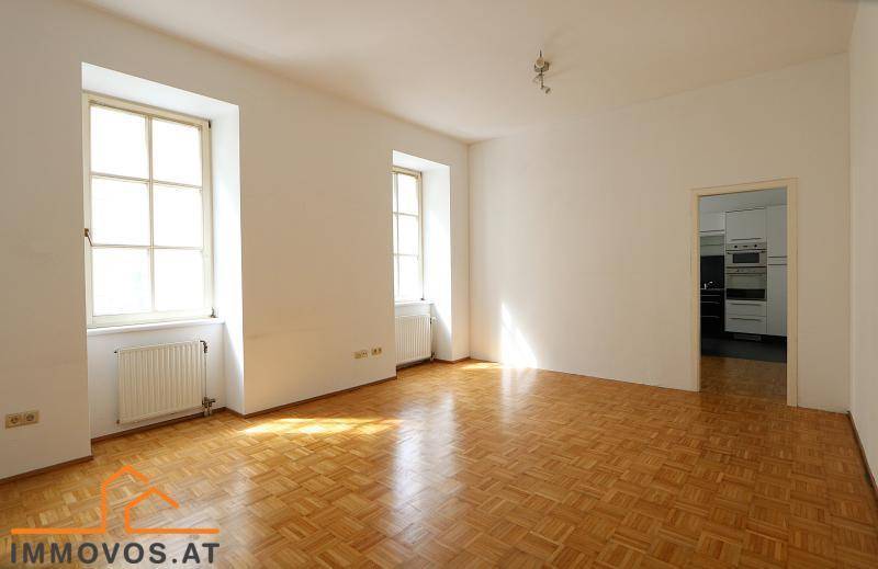 Geräumiges Zimmer mit Parkettboden und Zugang zu einem weiteren Raum, hell und vielseitig nutzbar.