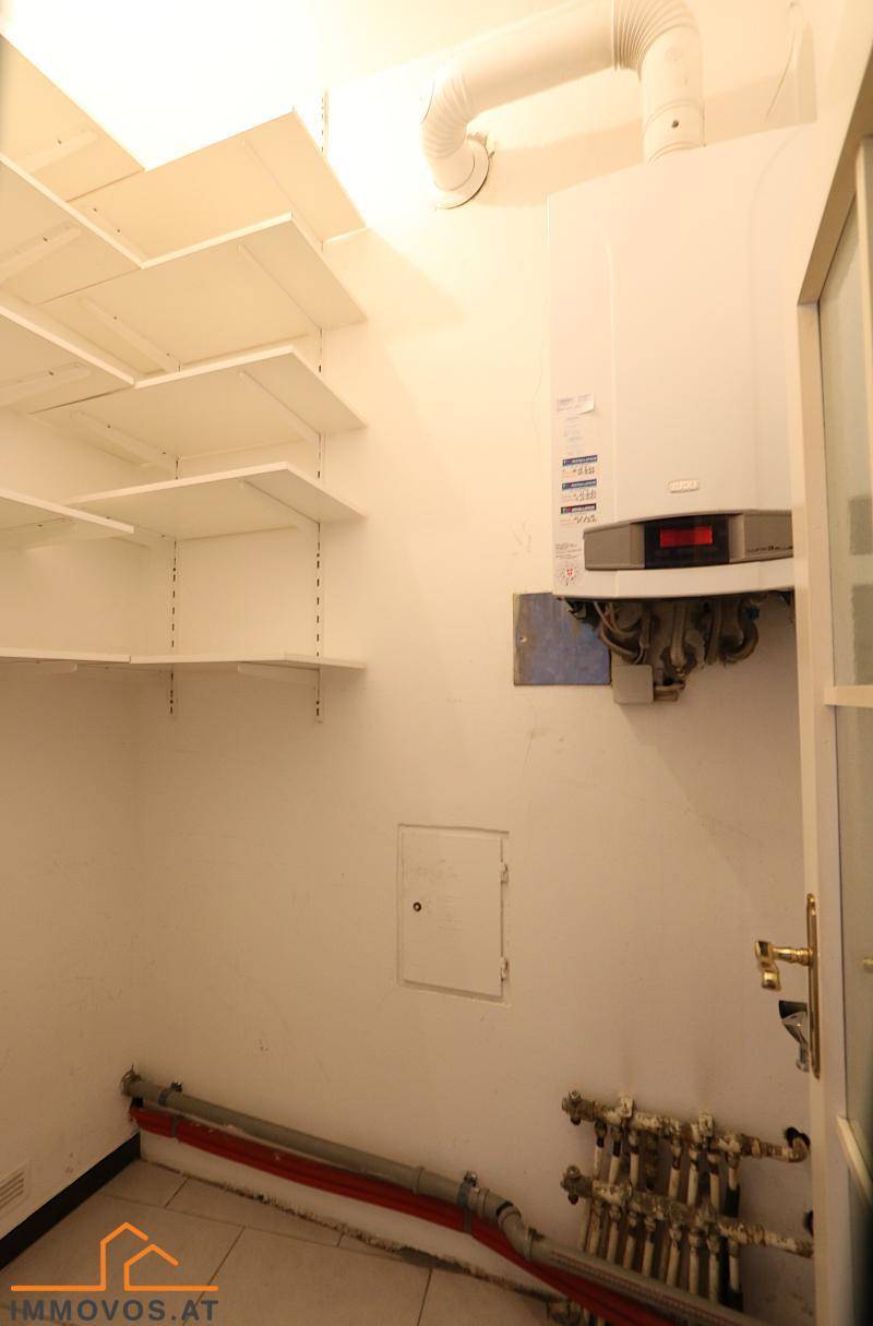 Praktischer Hauswirtschaftsraum mit Boiler, Installationen und Regalen für zusätzlichen Stauraum.