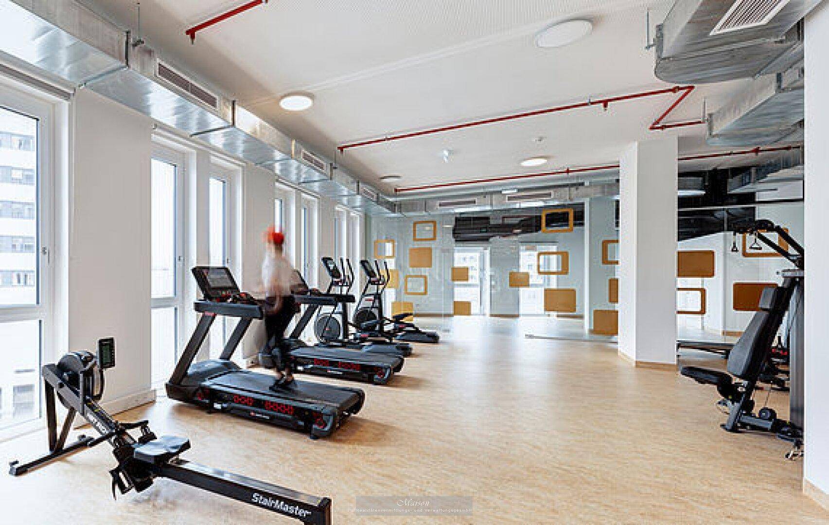 Heller Fitnessraum mit modernen Laufbändern und Trainingsgeräten, ideal für Sportbegeisterte.