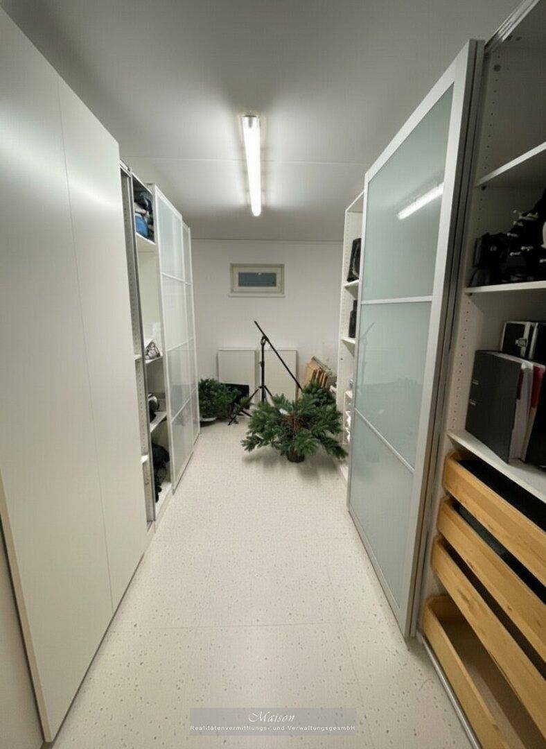 Heller begehbarer Kleiderschrank mit Regalen und Stauraum für Kleidung und Accessoires.