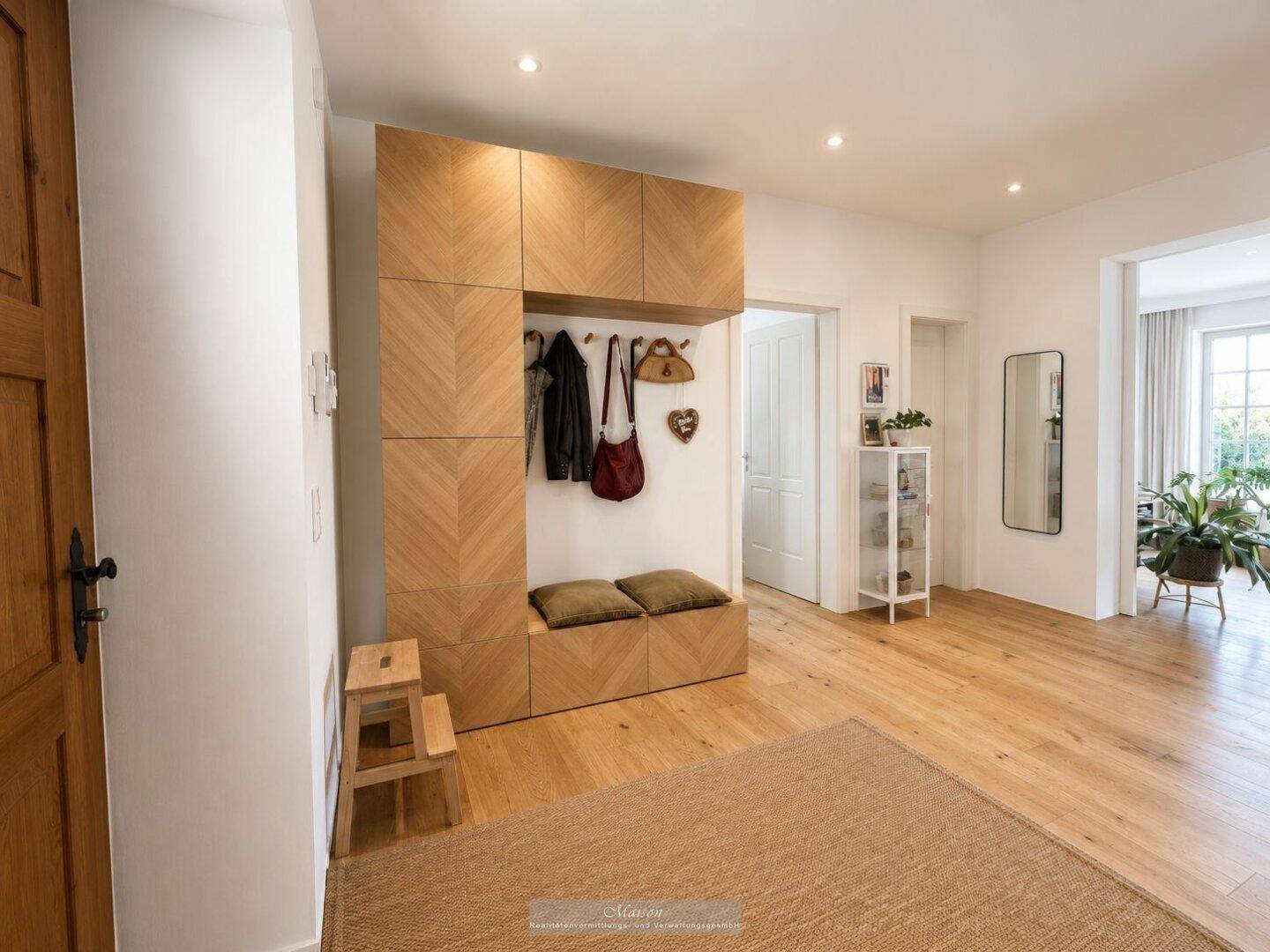 Heller Eingangsbereich mit moderner Holzgarderobe und Parkettboden.