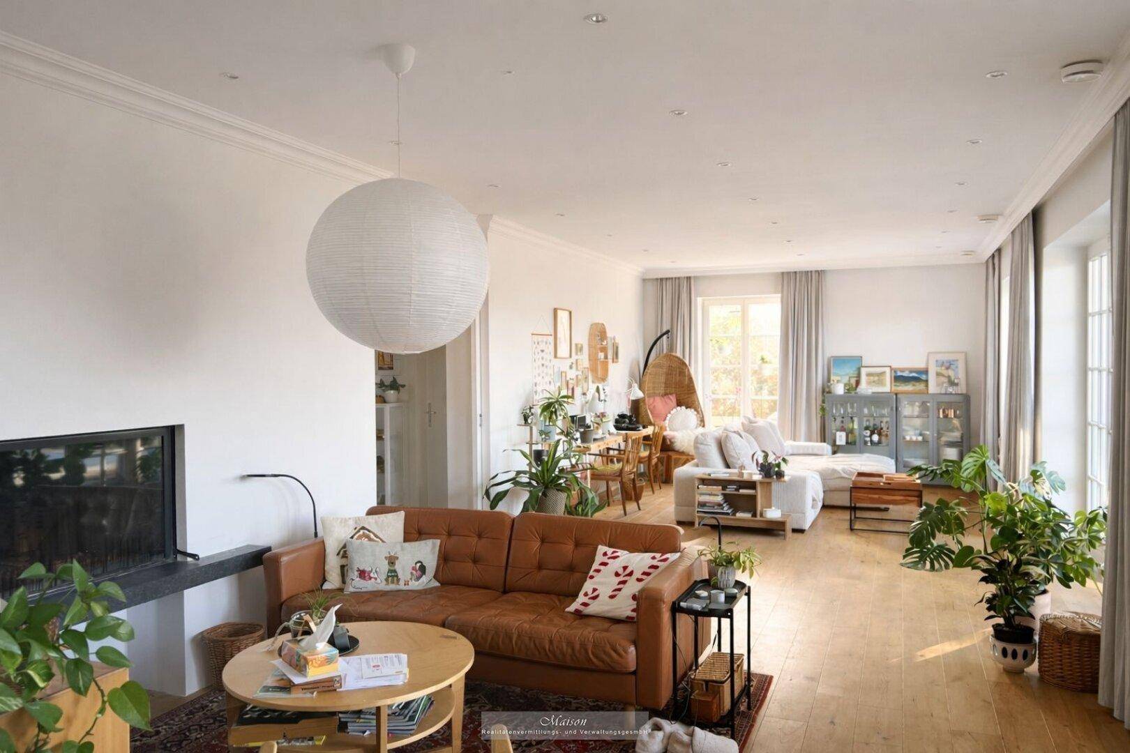 Geräumiges Wohnzimmer mit Ledersofa, Holzboden und moderner Einrichtung.