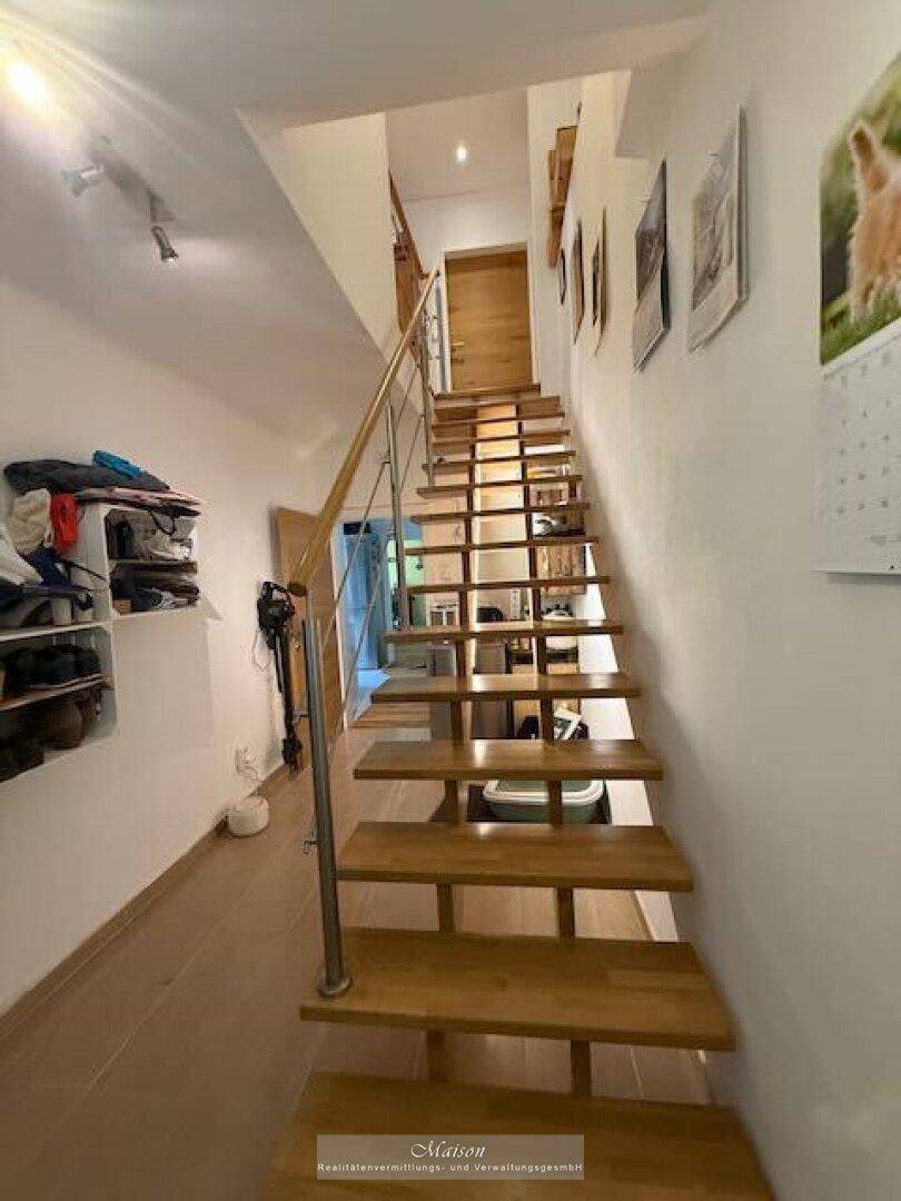 Geräumiger Flur mit Holztreppe und Blick auf den oberen Bereich.