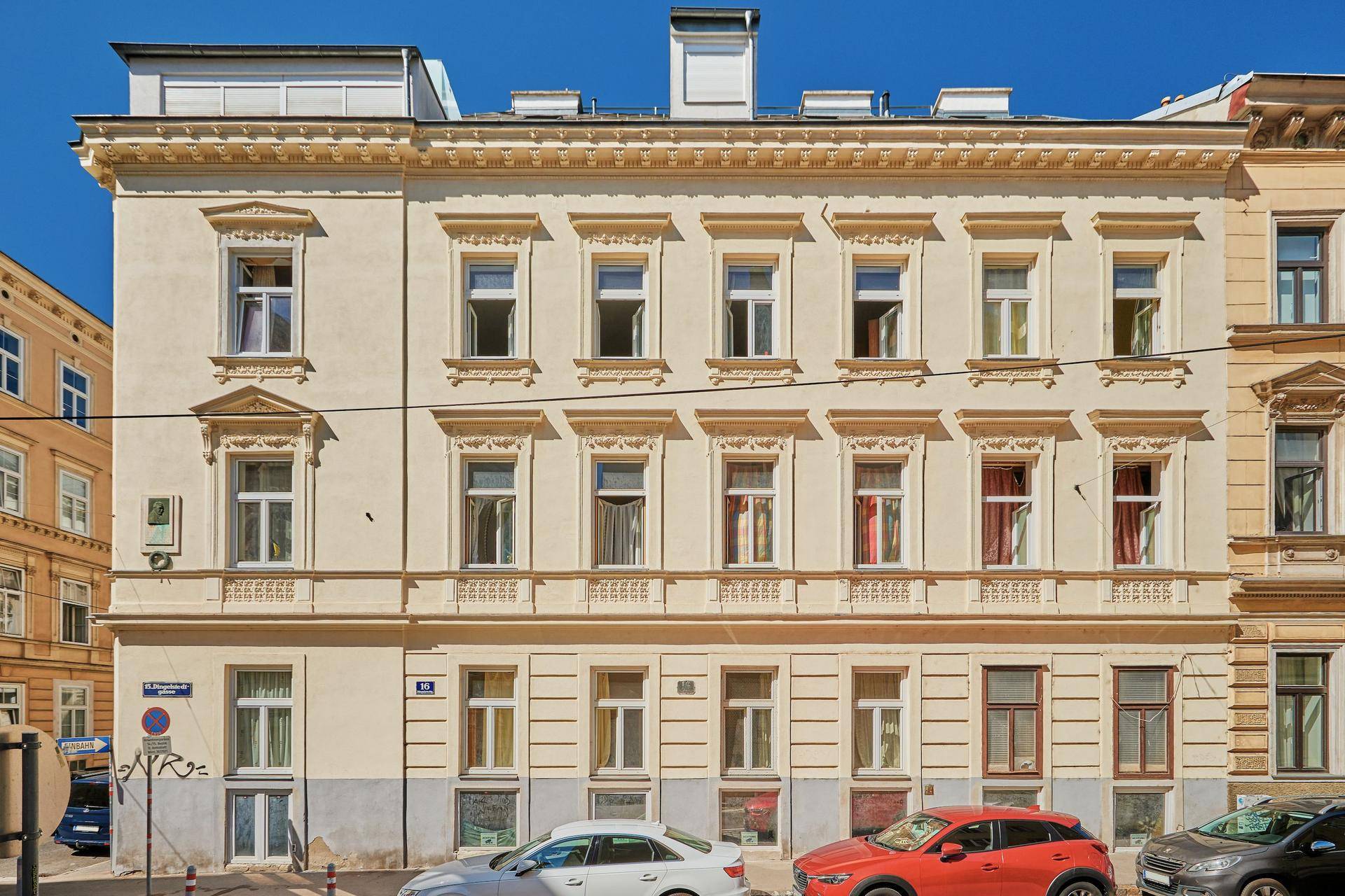 Vorderansicht des historischen Gebäudes mit mehreren Stockwerken und detaillierten Fensterrahmen in der Stadt.