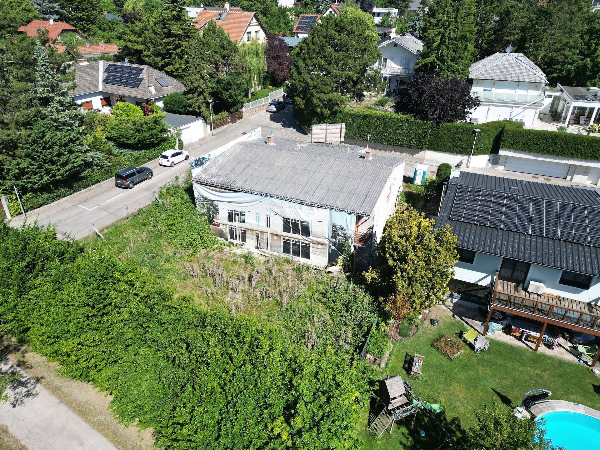Luftaufnahme eines im Bau befindlichen Hauses mit Garten und Pool in der Nachbarschaft.